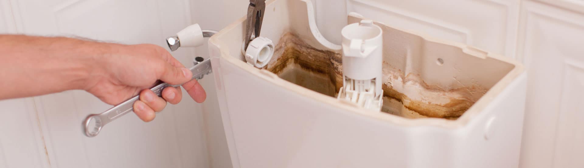 Tightening a connection behind a toilet cistern