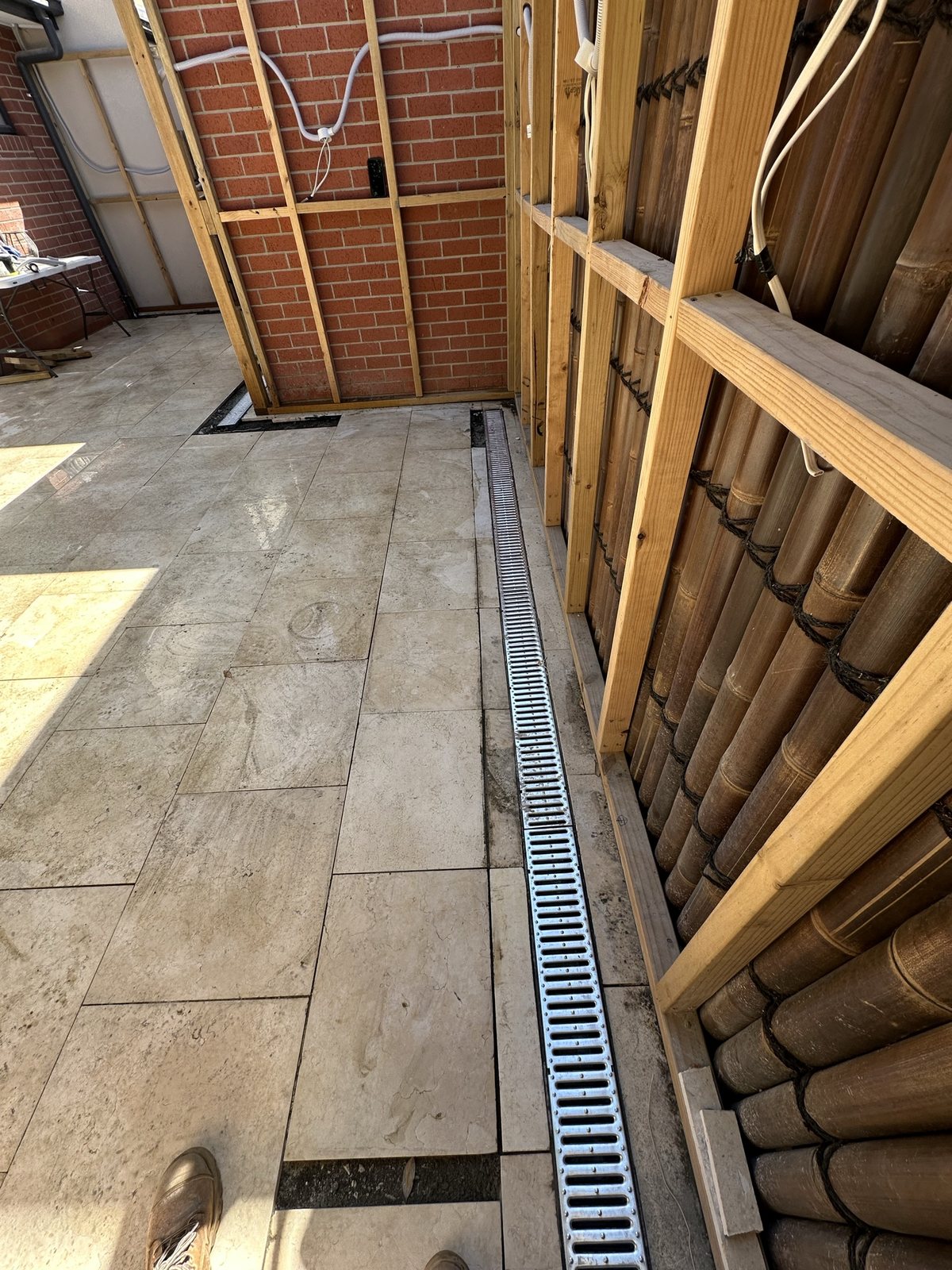 Completed stormwater channel drain beside reinstated courtyard paving in Essendon West