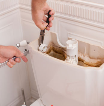 Tightening a connection behind a toilet cistern