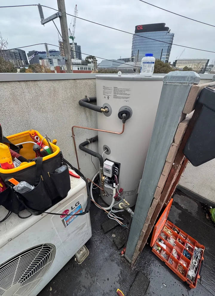 Hot-water repair in North Melbourne with the cylinder access panel open and tools beside it