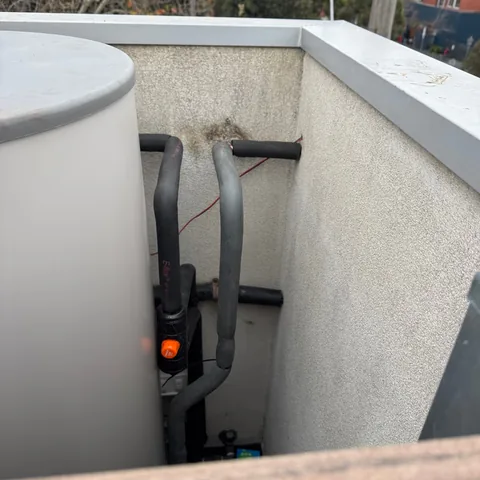 Insulated hot-water pipework beside a cylinder at a North Melbourne repair job