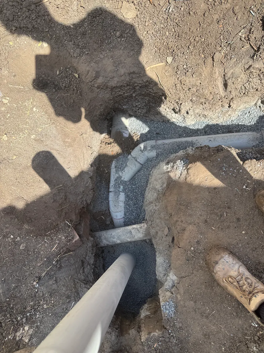 New PVC sewer fittings installed in an excavated trench